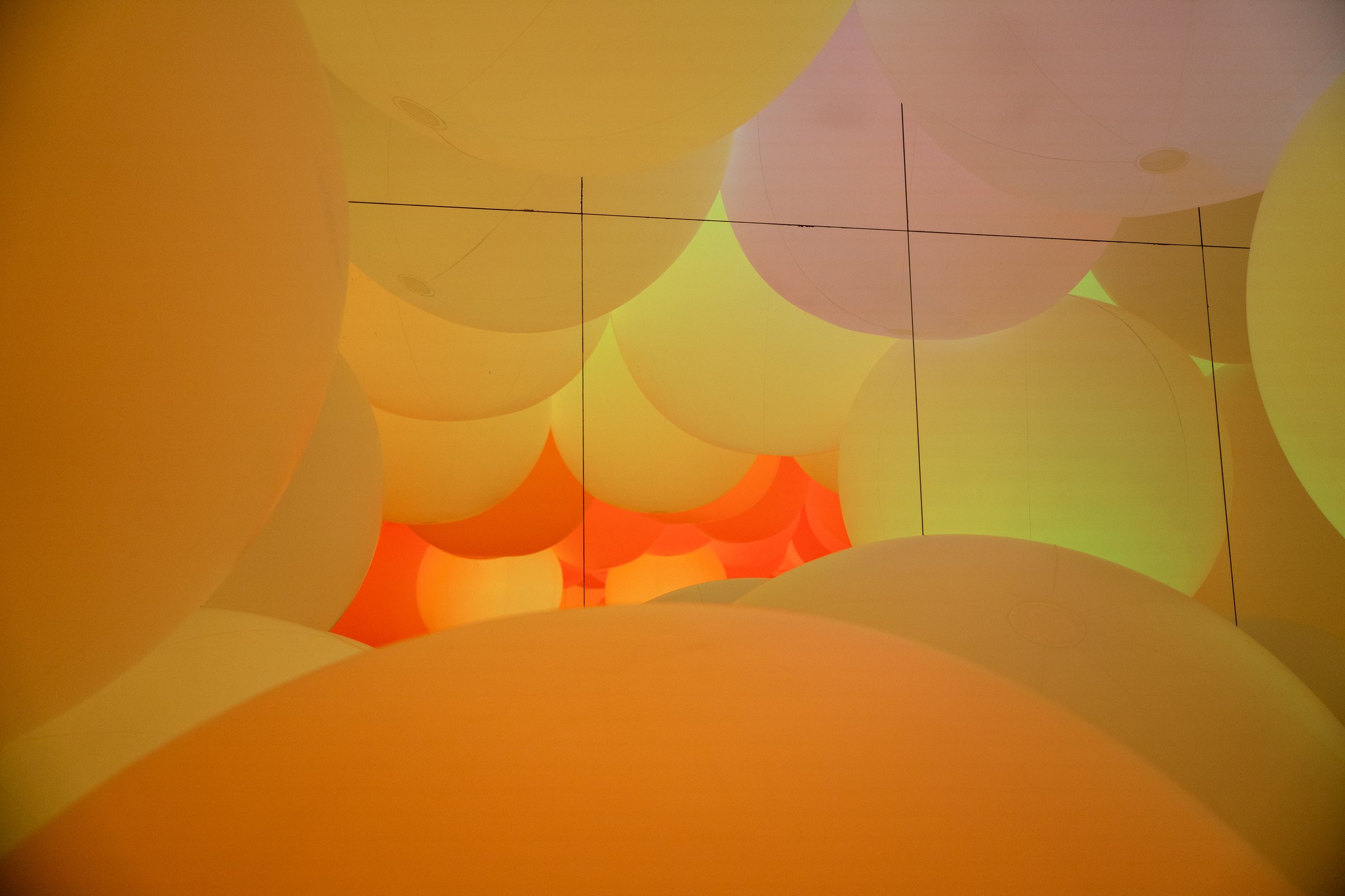 Colorful light projection installation casting geometric patterns in darkness